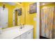 Bright yellow bathroom featuring decorative wall art, a tub, and a vanity at 3605 Kingsley Dr., Myrtle Beach, SC 29588