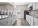 Well-lit kitchen with granite countertops, white cabinetry, stainless appliances, and open living area at 4027 Taranto Loop # C, Myrtle Beach, SC 29579