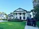 Elegant two-story home featuring a manicured lawn, palm trees, and a classic architectural design with prominent columns at 4110 Gray Heron Dr., North Myrtle Beach, SC 29582