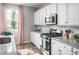 Bright kitchen featuring white cabinets, granite countertops, stainless steel appliances, and a large window at 437 Falling Leaf Loop, Myrtle Beach, SC 29588