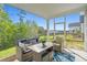 Cozy screened porch with stylish furniture, perfect for enjoying outdoor living with views of the green landscape at 4363 Bayshore Dr., Little River, SC 29566