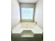 Large white soaking tub with tiled surround and a window providing natural light at 4394 Daphne Ln. # F, Murrells Inlet, SC 29576