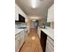Well-lit kitchen with white cabinetry, appliances, and laminate floors leading to an open dining area at 4394 Daphne Ln. # F, Murrells Inlet, SC 29576