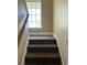 Staircase with carpeted steps, wooden handrail, and a window providing natural light to the landing at 4394 Daphne Ln. # F, Murrells Inlet, SC 29576
