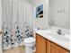 Bright bathroom featuring a floral shower curtain, white vanity with wooden cabinets, and modern fixtures at 454 Sean River Rd., Conway, SC 29526