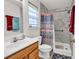 Bathroom with a vanity, toilet, and a marble-walled shower with a shower curtain and safety bar at 454 Sean River Rd., Conway, SC 29526