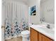 Bright bathroom featuring a floral shower curtain, white vanity with wooden cabinets, and modern fixtures at 454 Sean River Rd., Conway, SC 29526