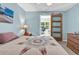 Light blue bedroom featuring a bed with a quilt, sliding barn door, and a glimpse into another room at 454 Sean River Rd., Conway, SC 29526