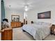 Cozy main bedroom with a large bed, dresser, and carpeted floors, illuminated by a ceiling fan at 454 Sean River Rd., Conway, SC 29526