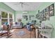 Bright sunroom features lots of windows, ceiling fan, herringbone floors, and comfortable seating area at 454 Sean River Rd., Conway, SC 29526