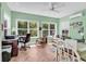 Bright sunroom with lots of windows offering a view of trees, a ceiling fan, and beautiful herringbone floors at 454 Sean River Rd., Conway, SC 29526