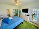 Bright bedroom featuring a blue comforter, mounted TV, and access to both a bathroom and outdoor patio at 4783 Wild Iris Dr. # 101, Myrtle Beach, SC 29577