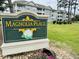 Magnolia Place entrance sign with flowers and beautiful landscaping at 4783 Wild Iris Dr. # 101, Myrtle Beach, SC 29577
