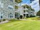 Exterior view of a condo with a lush lawn and ample landscaping at 4783 Wild Iris Dr. # 101, Myrtle Beach, SC 29577