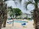 View of the community pool and lounge area nestled between palm trees and condominium buildings at 4783 Wild Iris Dr. # 101, Myrtle Beach, SC 29577
