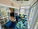 Relaxing sun room with sliding doors, wicker furniture, and tropical themed rug and decorations at 4783 Wild Iris Dr. # 101, Myrtle Beach, SC 29577