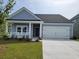 Inviting one-story home with a covered porch, a two-car garage, and well-maintained lawn at 519 Magnolia Terrace Dr, Myrtle Beach, SC 29579