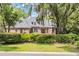 Stunning brick home with a mature, tree-lined lawn and manicured hedges at 520 Chapman Loop, Pawleys Island, SC 29585