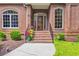 Welcoming brick front porch with beautiful door and potted colorful flowers at 520 Chapman Loop, Pawleys Island, SC 29585
