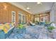 Beautiful sunroom with brick walls, arched windows, comfortable seating, and a blue patterned rug at 520 Chapman Loop, Pawleys Island, SC 29585