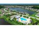 A scenic aerial shot of a community, featuring a pool, clubhouse, a pond with a fountain, and lush green landscaping at 5406 Longhorn Dr., Myrtle Beach, SC 29588