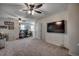 Bright room featuring ceiling fans, neutral carpet, a large TV, and a dedicated workspace for modern living at 5406 Longhorn Dr., Myrtle Beach, SC 29588