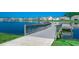 A scenic view of a wooden pier extending into a peaceful lake, lined with green grass and community homes at 5406 Longhorn Dr., Myrtle Beach, SC 29588