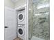 This bathroom includes stacked washer-dryer, glass shower with marble-look tile, and modern vanity at 6001 - 1793 S Kings Hwy., Myrtle Beach, SC 29575
