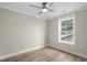 This bedroom features wood-look floors, neutral walls, white trim, plus a bright window and modern ceiling fan with light at 6001 - 1793 S Kings Hwy., Myrtle Beach, SC 29575