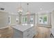 Kitchen island with marble countertops, and pendant lights opening to living room with lots of windows at 6001 - 1793 S Kings Hwy., Myrtle Beach, SC 29575
