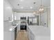 Modern kitchen with white cabinets, marble countertops, stainless appliances, and statement pendant lights at 6001 - 1793 S Kings Hwy., Myrtle Beach, SC 29575