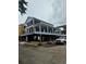 Coastal home with a blue exterior, black railing, and a large covered deck on multiple levels at 6001 - Mh-13B S Kings Hwy., Myrtle Beach, SC 29575