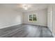 Large bedroom with wood flooring, base trim, a window, and access to an outdoor patio at 61 Yale Pl., Pawleys Island, SC 29585