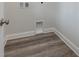 An interior laundry room featuring a white wall and modern wooden floor at 61 Yale Pl., Pawleys Island, SC 29585