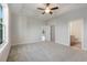 Spacious bedroom with carpet, tray ceiling and a ceiling fan, leading into the ensuite bathroom at 61 Yale Pl., Pawleys Island, SC 29585