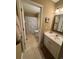 Bright bathroom featuring tiled floors, white vanity, framed mirror, and shower with a seashell patterned curtain at 6103 N Ocean Blvd. # C-6, North Myrtle Beach, SC 29582