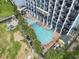 Top-down shot of resort pool, hot tub, and water bridge, surrounded by lush landscaping and balconies at 6804 N Ocean Blvd. # 829, Myrtle Beach, SC 29572