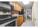 Compact kitchen with essential appliances, wooden cabinets, tile floor, and view to the bedroom at 6804 N Ocean Blvd. # 829, Myrtle Beach, SC 29572