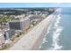 The aerial view showcases a beautiful coastline with white sandy beaches, clear blue waters, and towering resorts at 7100 N Ocean Blvd. # 320, Myrtle Beach, SC 29572