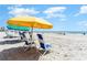 A sunny beach view featuring beach chairs and yellow and green umbrellas, offering a relaxing seaside experience at 7100 N Ocean Blvd. # 320, Myrtle Beach, SC 29572