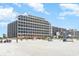 A pristine beach with a wide expanse of white sand, gentle waves, and a towering high-rise resort in the background at 7100 N Ocean Blvd. # 320, Myrtle Beach, SC 29572