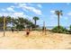A beach volleyball court sits on the sandy shore surrounded by lush greenery and swaying palm trees at 7100 N Ocean Blvd. # 320, Myrtle Beach, SC 29572