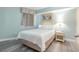Cozy bedroom with a queen bed, wood-look flooring, and a decorative window treatment at 7100 N Ocean Blvd. # 320, Myrtle Beach, SC 29572