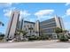 A daytime, street-level view of the oceanfront building featuring palm trees and striking architecture at 7100 N Ocean Blvd. # 320, Myrtle Beach, SC 29572