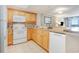 Close-up view of kitchen with white appliances and wood cabinets, backsplash and decorative tile at 7100 N Ocean Blvd. # 320, Myrtle Beach, SC 29572