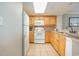 Well-equipped kitchen with white appliances, wood cabinets, and a convenient breakfast bar at 7100 N Ocean Blvd. # 320, Myrtle Beach, SC 29572