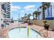 The pool deck has lounge chairs, tables, umbrellas and a unique fountain, all surrounded by a resort building at 7100 N Ocean Blvd. # 320, Myrtle Beach, SC 29572