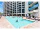 An outdoor swimming pool with lounge chairs offers a relaxing atmosphere next to a high-rise building at 7100 N Ocean Blvd. # 320, Myrtle Beach, SC 29572