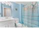 Bathroom with a white sink, seashell-themed shower curtain, toilet, and light blue walls at 736 Flowering Branch Ave., Little River, SC 29566
