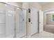 Bathroom with a tiled shower, glass door, and ' ' and ' ' towel hooks on the wall at 736 Flowering Branch Ave., Little River, SC 29566